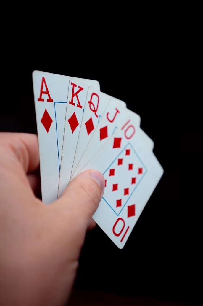 Person holder en pokerhånd med spillekort